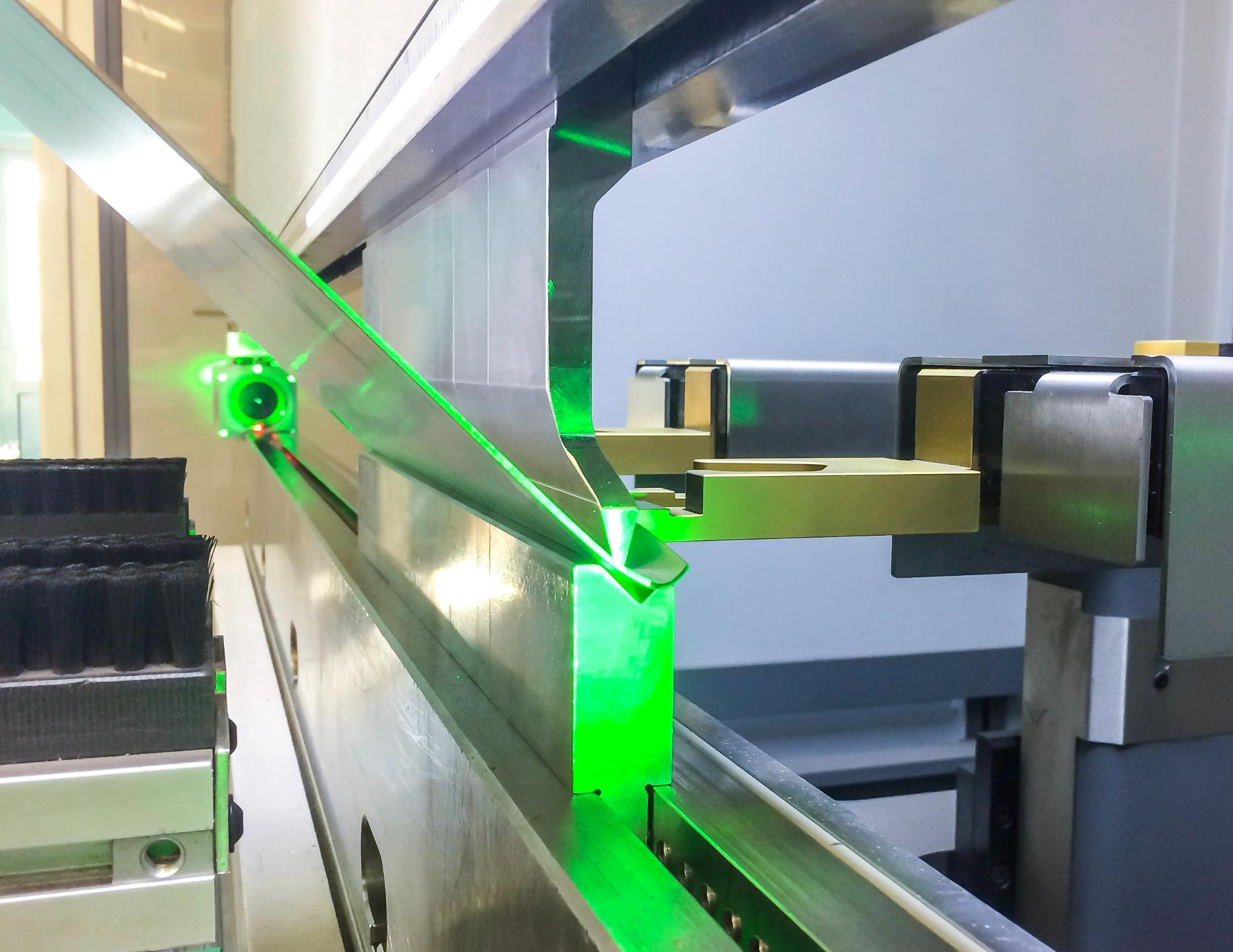 Sistema de visión artificial con láser midiendo dimensiones de pieza metálica en proceso industrial