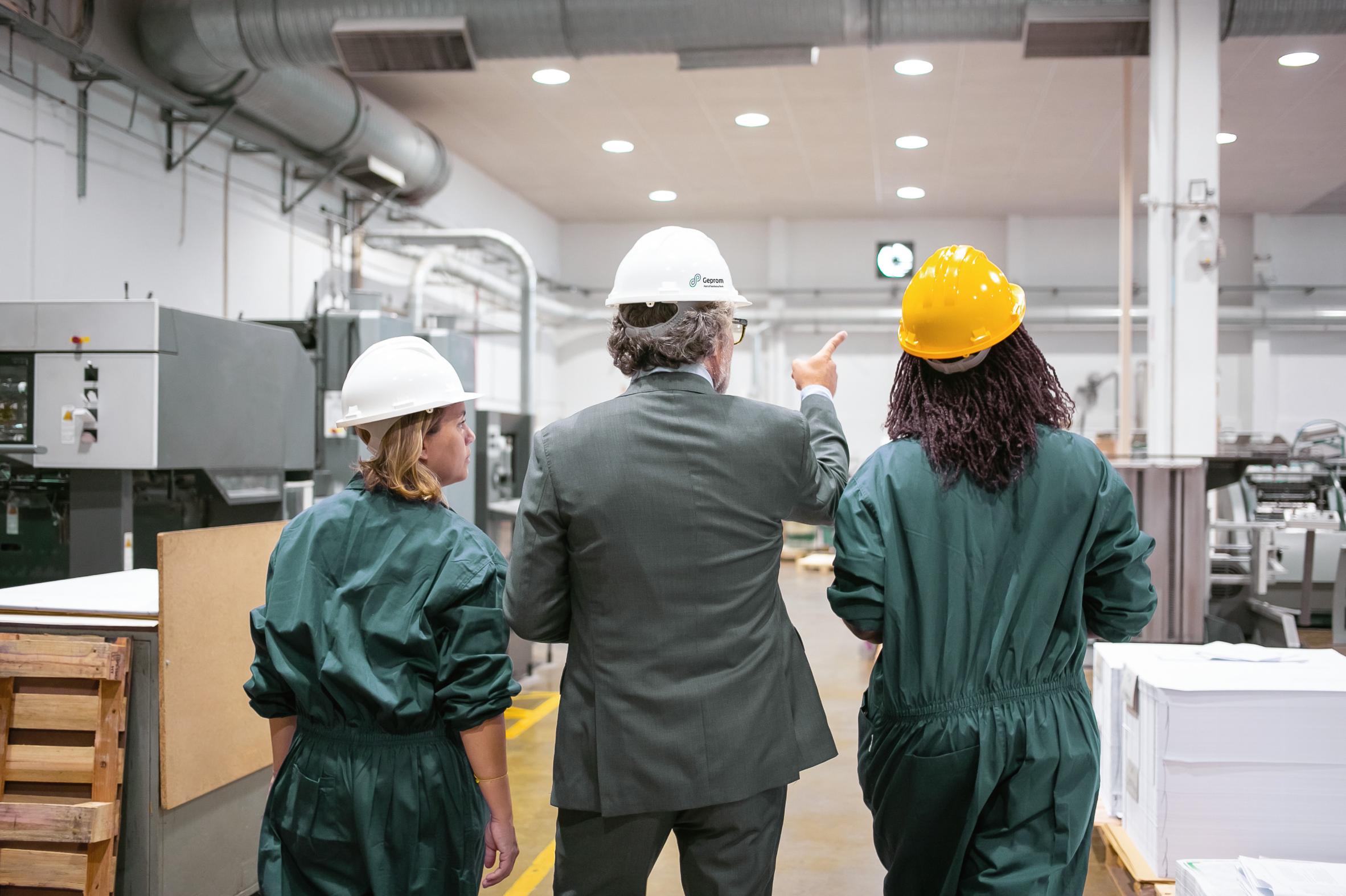 Director coordinando al equipo en planta industrial durante recorrido de supervisión.